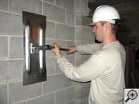 Attempting to straighten a bowed foundation wall by straightening a wall anchor system in a Wisconsin Rapids home.
