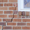 long jagged cracks starting at the corner of a window along a brick wall on a Sturgeon Bay home